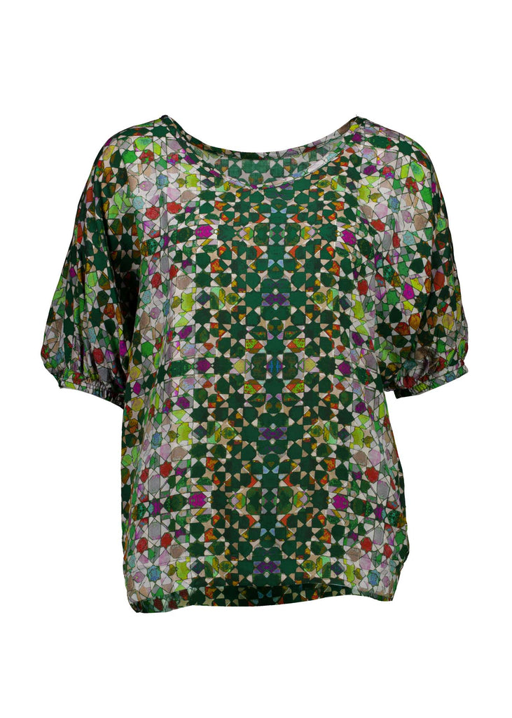 Olga de Polga Kaleidoscope Green Camisa Blouse in printed fine Tencel. This is a reversible top with the choice of a soft V-neck and a boat neck which are interchangeable. Half length sleeves. Finishes at the hip. Front view.