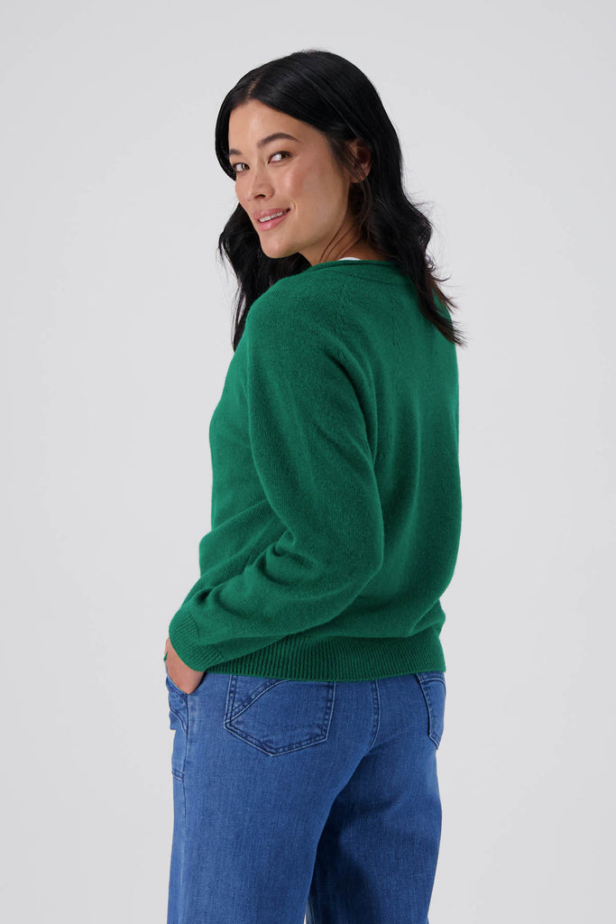 Green Olga de Polga Kyoto cardigan in a wool cashmere blend. With a round neckline and long sleeves, this cardigan has a button down front with small unique buttons. Side back view