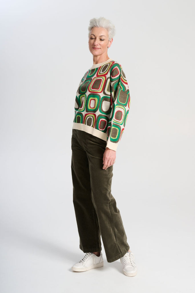 Olga de Polga retro patterned knit Bristol Lush green sweater in a soft merino wool blend. Long sleeves, and round neckline. Side view on model