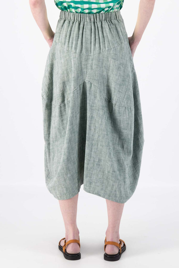 Olga de Polga Milwaukee Panorama woven skirt in Green. Our Milwaukee Skirt is an incredibly unique, chic and original skirt. It is universally flattering, highly versatile, and super comfortable. Perfect to throw on and go. Back close-up view on model.