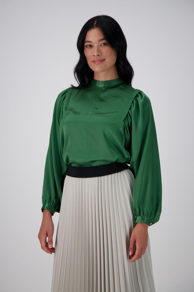 Olga de Polga Green Moonshine Blouse in satin. Billowing sleeves and a round neck make this the perfect blouse to dress up or down for any occasion. Front view, tucked into a skirt.