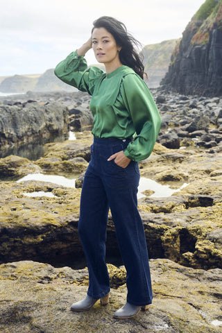 Olga de Polga Green Moonshine Blouse in satin. Billowing sleeves and a round neck make this the perfect blouse to dress up or down for any occasion. Side front view on model.