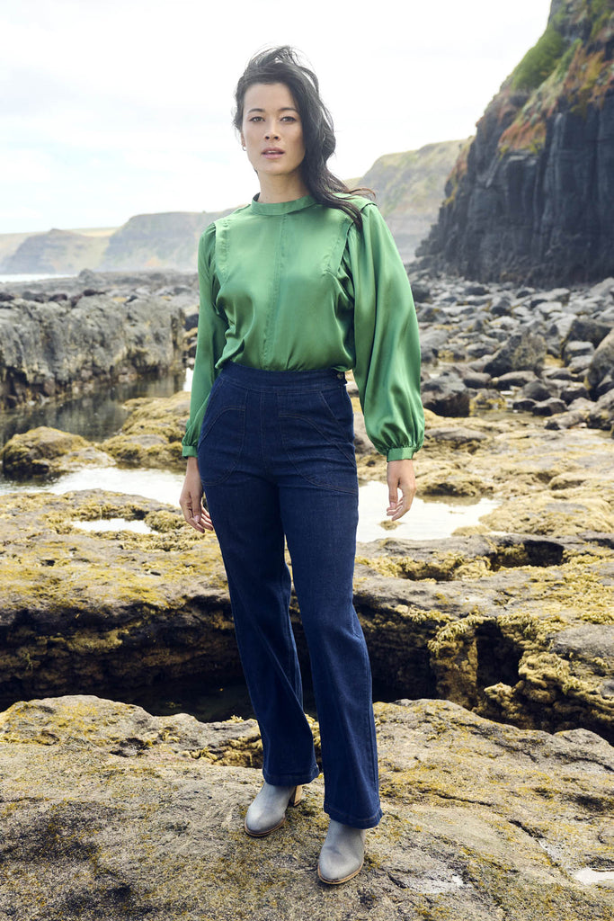 Olga de Polga Green Moonshine Blouse in satin. Billowing sleeves and a round neck make this the perfect blouse to dress up or down for any occasion. Front outdoor view on model