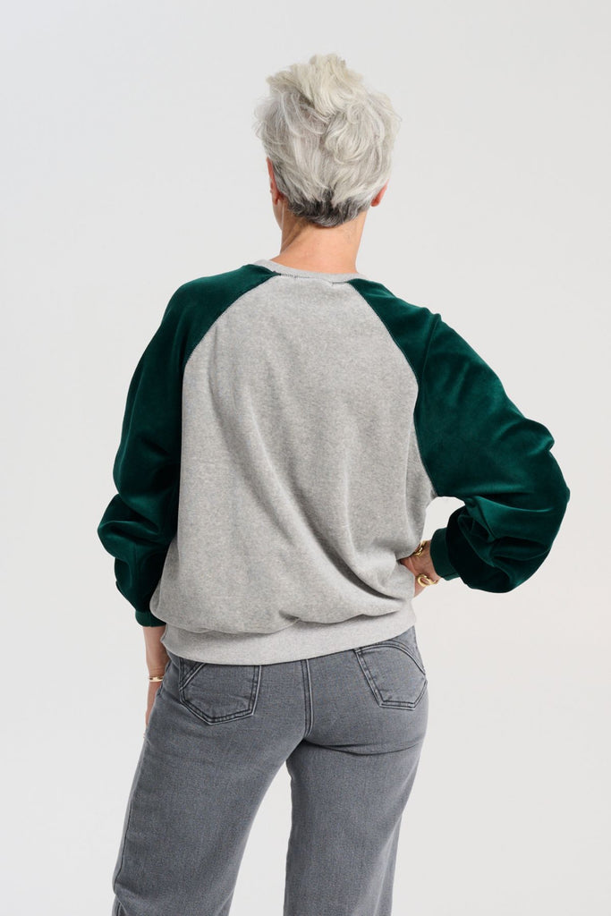 Olga de Polga Green Odessa Sweatshirt. The Odessa Sweatshirt combines comfort and style in a two-tone colour design. Crafted from soft cotton velour, it’s perfect for mild weather and busy days when versatility and comfort are key.  Back view on model