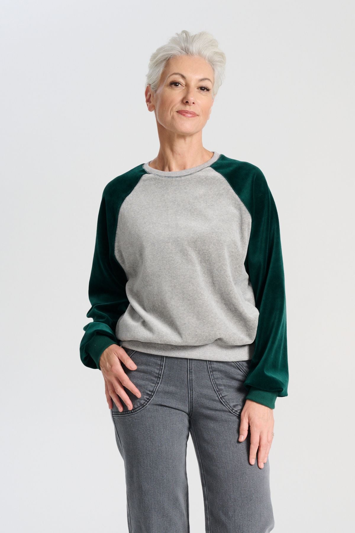 Olga de Polga Green Odessa Sweatshirt. The Odessa Sweatshirt combines comfort and style in a two-tone colour design. Crafted from soft cotton velour, it’s perfect for mild weather and busy days when versatility and comfort are key. Front view on model.