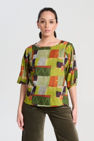 Olga de Polga classic blouse in green Kismet Sage printed cotton seersucker. The blouse features a beautifully detailed lantern sleeve with a drop shoulder and delicate pleating on the shoulder and cuff. It also has a wide boat neckline and invisible zip fastening at the back. Front view on model.