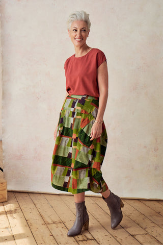 Olga de Polga Sage green Kismet printed Milwaukee skirt in fine cord. Large patch pockets. Unique panelled design. Back elasticated waistband.  Side front view on model.