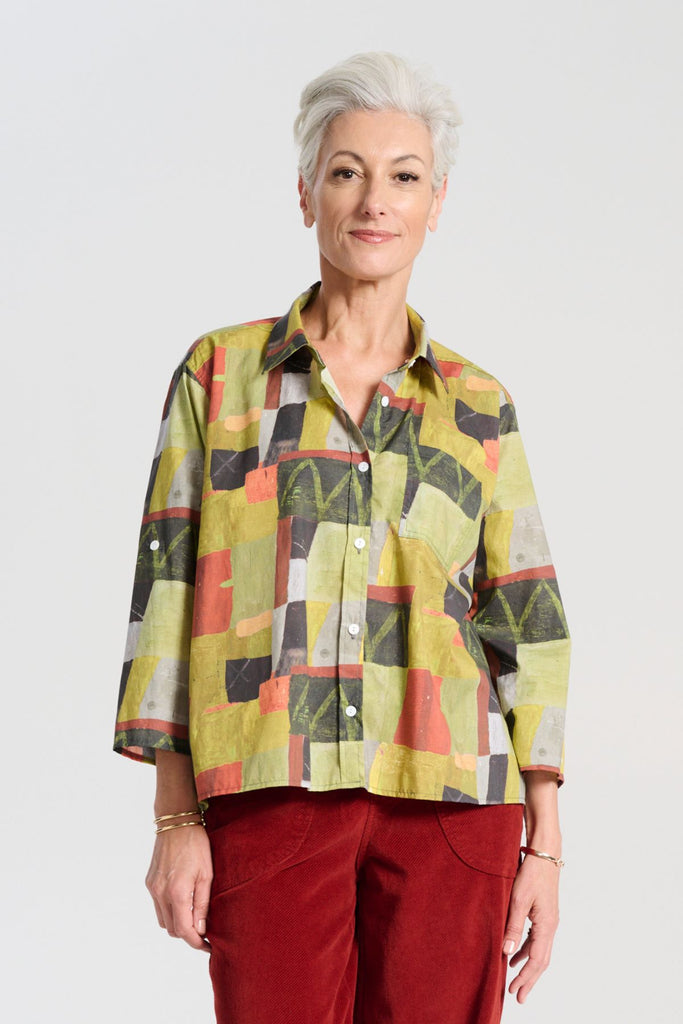 Olga de Polga green classic shirt in the Kismet Sage printed cotton. An effortlessly chic, relaxed silhouette that drapes with ease. Button up front, 3/4 sleeves, collar, dropped shoulders. Longer at back hem. Front view on model.