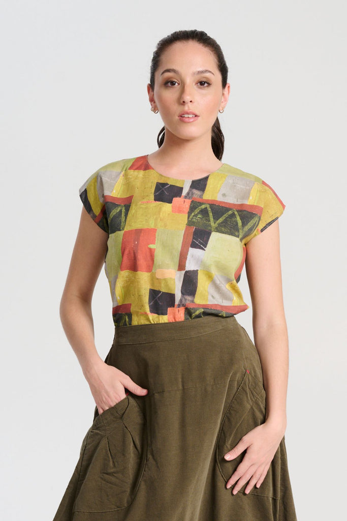 Olga de Polga tee in Sage Kismet printed soft wash cotton. Round neckline, cap sleeves. Tapers in slightly at the waist. Front view on model.