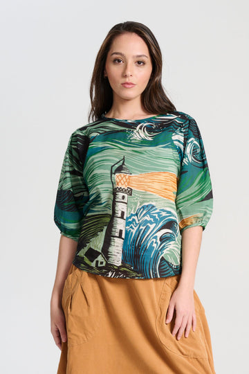Olga de Polga green Isla Tide blouse in printed cotton seersucker. Our signature Olga Blouse is a feminine staple that can take you from work to weekend with ease. The blouse features a beautifully detailed lantern sleeve with a drop shoulder and delicate pleating on the shoulder and cuff. It also has a wide boat neckline and invisible zip fastening at the back. Front view on model.