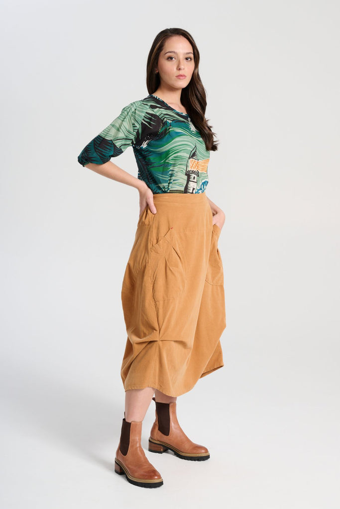 Olga de Polga green Isla Tide blouse in printed cotton seersucker. Our signature Olga Blouse is a feminine staple that can take you from work to weekend with ease. The blouse features a beautifully detailed lantern sleeve with a drop shoulder and delicate pleating on the shoulder and cuff. It also has a wide boat neckline and invisible zip fastening at the back. side view on model.