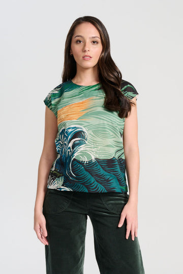 Olga de Polga Isla tee in Tide green printed cotton voile. With cap sleeves, a round neckline with a button fastening at the back neck, tapering in at the waist and finishing at the hip, this tee is perfect for all occasions. Front view on model.
