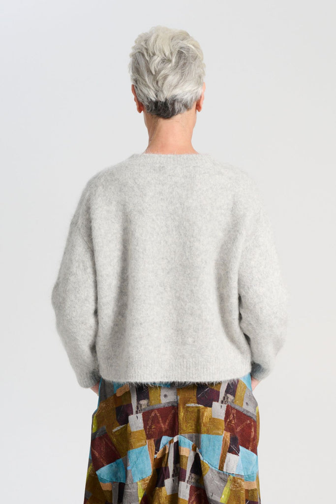 Olga de Polga Aspen sweater in Light Grey. With its soft alpaca blend, and insulating warmth, it’s the perfect staple for layering or wearing on its own. Back view on model
