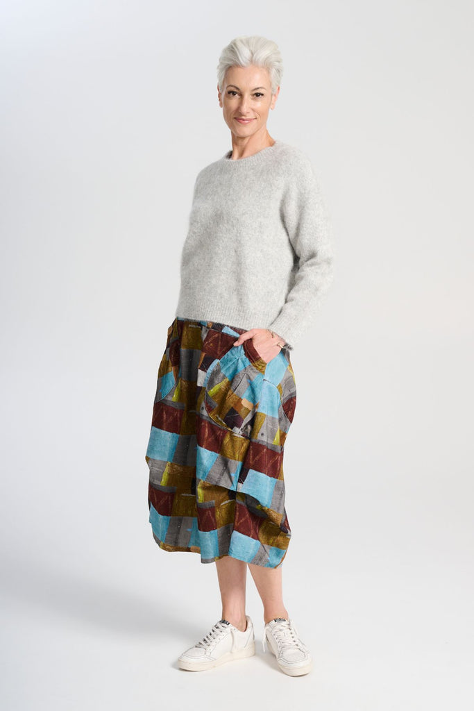 Olga de Polga Aspen sweater in Light Grey. With its soft alpaca blend, and insulating warmth, it’s the perfect staple for layering or wearing on its own. Side front view full length on model.