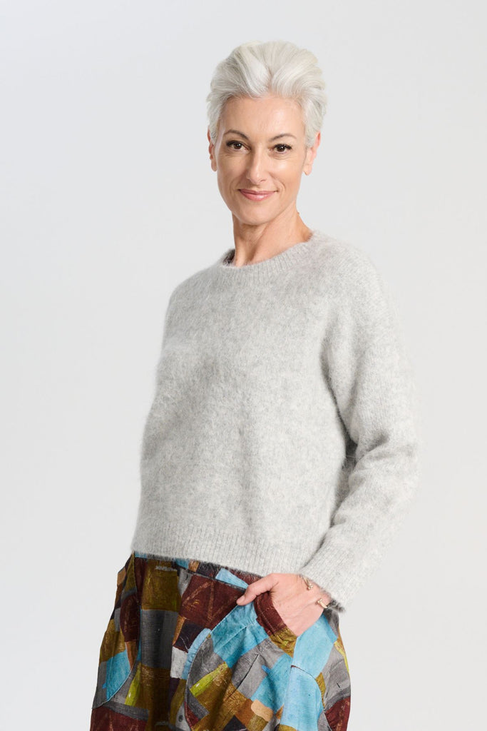 Olga de Polga Aspen sweater in Light Grey. With its soft alpaca blend, and insulating warmth, it’s the perfect staple for layering or wearing on its own. Side view on model