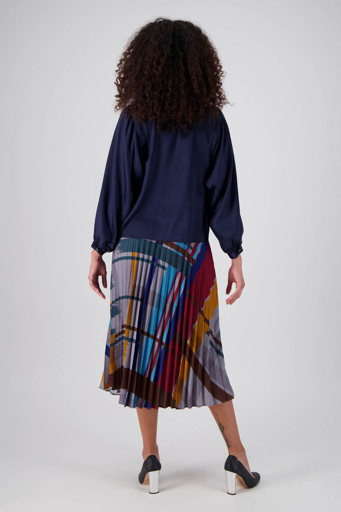 Olga de Polga pleated skirt in our Crossroads Primary printed recycled polyester. Elasticated waistband. Midi length.  Back full length view