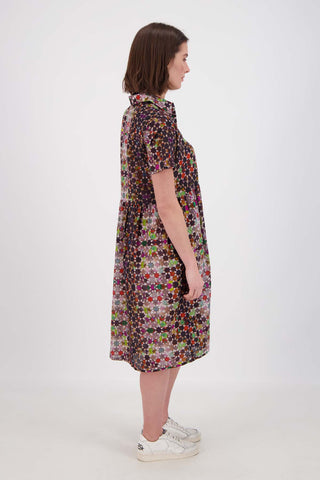 Olga de Polga Grey Kaleidoscope printed Villa dress in long length. Shirt dress with a button front. Finishes just below the knee. 100% Cotton. Side view on model.