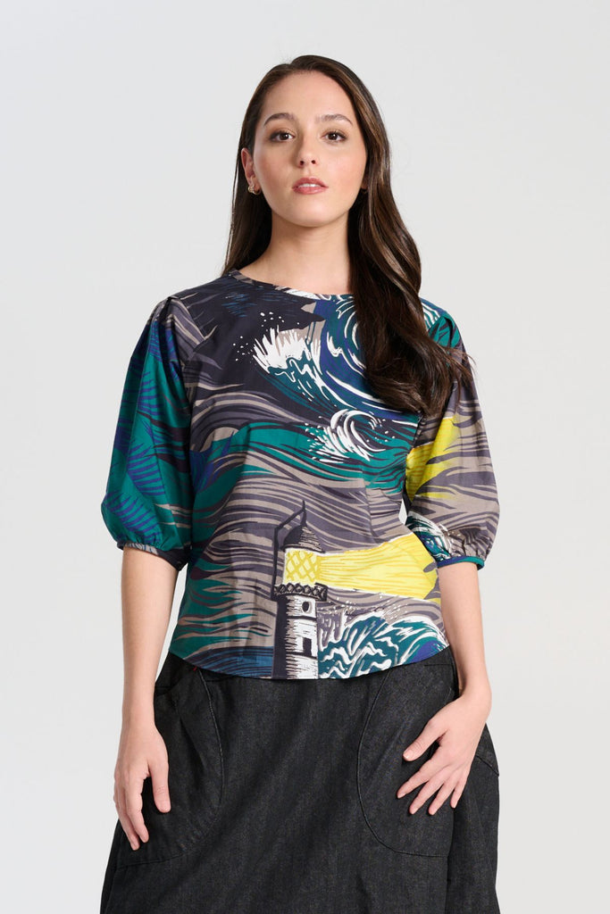 Olga de Polga classic blouse in the Storm Isla printed cotton. The blouse features a beautifully detailed lantern sleeve with a drop shoulder and delicate pleating on the shoulder and cuff. It also has a wide boat neckline and invisible zip fastening at the back. Front view on model