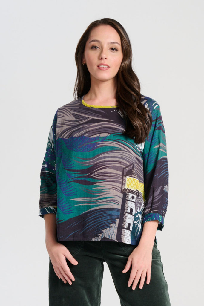 Olga de Polga Chemise blouse in the Isla Storm printed cotton from our Odyssey AW25 collection. this blouse features a flattering round neckline, a single button closure at the back, and a longer length than our signature blouse. The straight sleeves are finished with a simple cuff detail with a subtle box pleat. Front view on model.