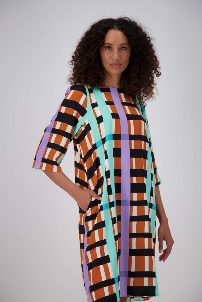 Olga de Polga multi coloured geometric printed Madras shift dress.  Side front close-up view on model