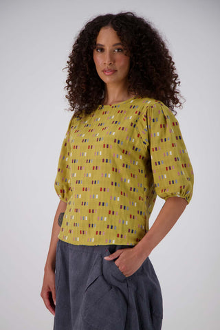 Olga de Polga Mustard Telegraph Blouse in woven cotton.  Side front view on model