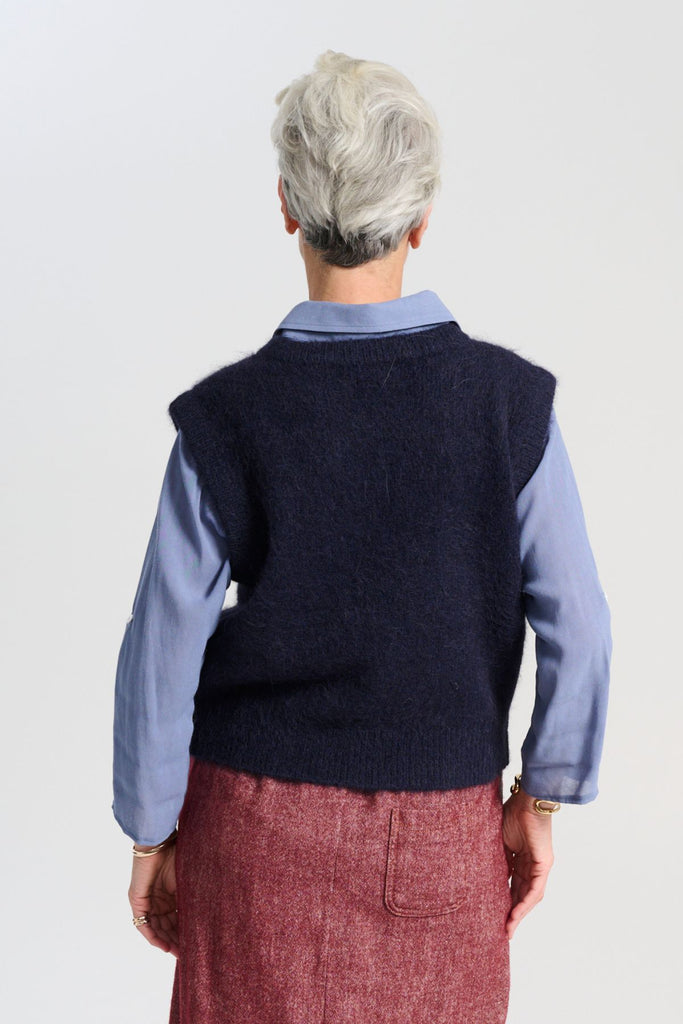 Olga de Polga Navy Aspen alpaca knit vest. Ribbing at neckline and hem. A beautifully textured knit vest—your perfect layering essential for effortless, trans-seasonal styling. Back view on model