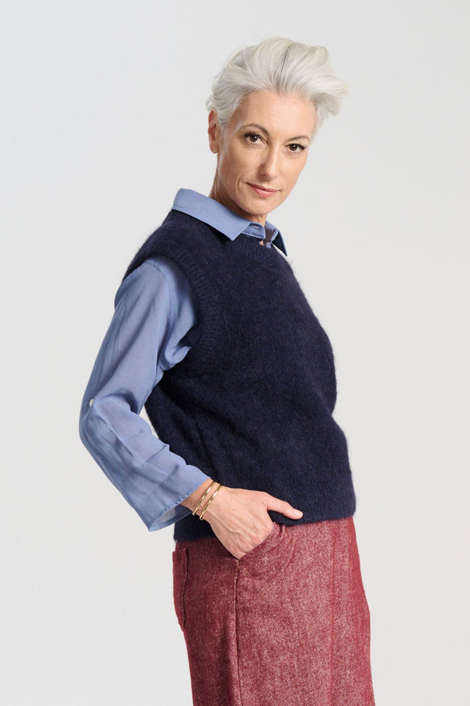 Olga de Polga Navy Aspen alpaca knit vest. Ribbing at neckline and hem. A beautifully textured knit vest—your perfect layering essential for effortless, trans-seasonal styling. Side view on model.