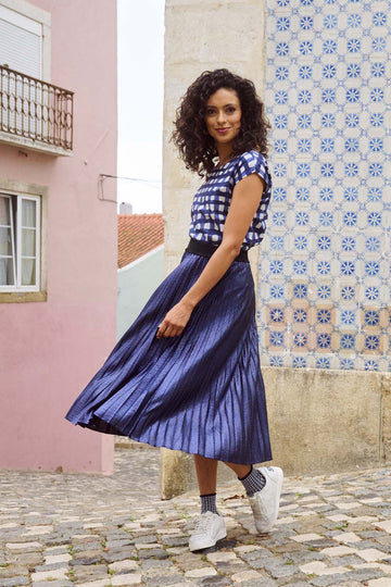 Olga de Polga Navy Champagne pleated skirt in 100% recycled polyester. Side front view on model.