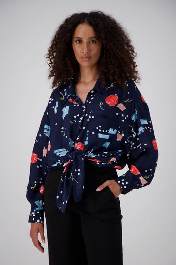 Olga de Polga LAX shirt in an oversized fit with long sleeves and button down front. Tie at the waist or wear loose over a t-shirt. Front view on model