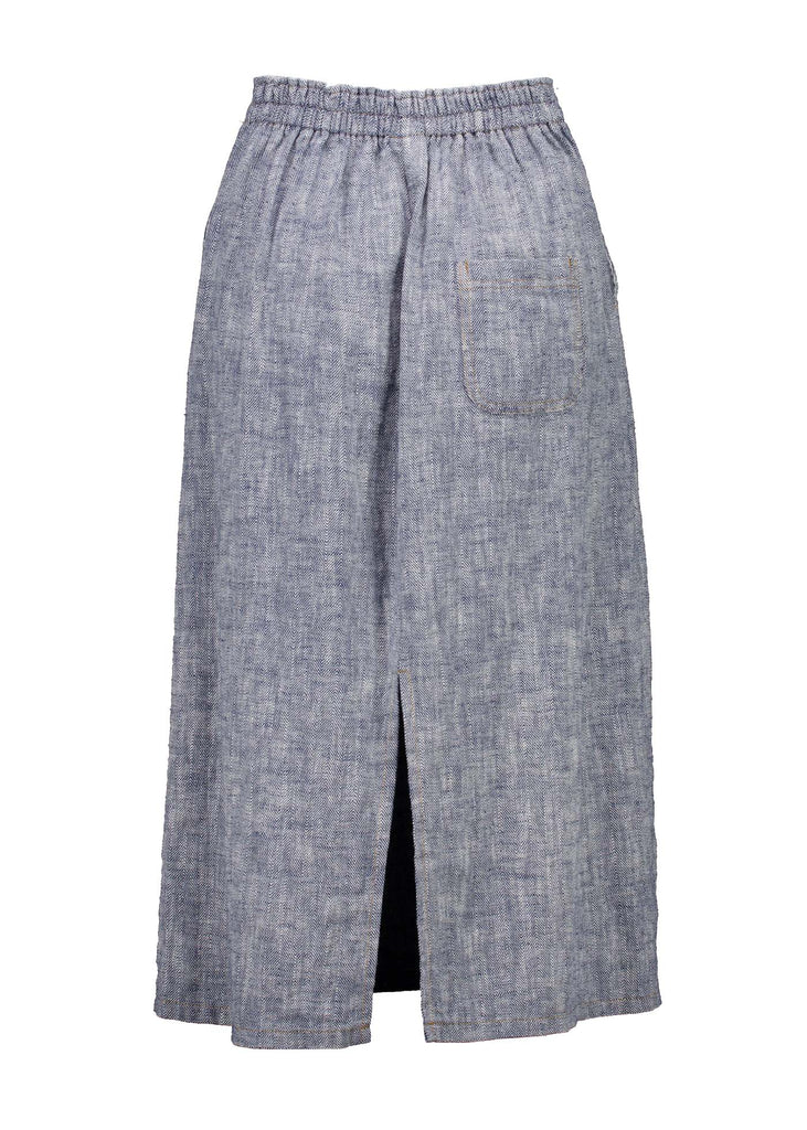 Olga de Polga Navy Hepburn skirt in Herringbone linen.  Featuring a unique button detail at the waist that forms a flattering pocket shape, this skirt adds personality to any outfit. With an elasticated back waist for comfort, it finishes just below the knee and has a stylish back split for ease of movement. Effortlessly refined yet practical, it's a wardrobe must-have for day-to-night versatility. Back.