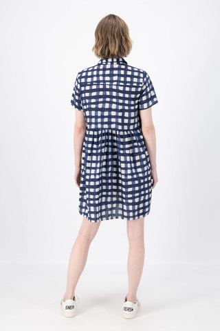 Olga de Polga's Villa drop waist dress in Rosa Navy printed 100% cotton fabric. Short sleeves, button front, collar, finishes at the knee, depending on height. Back full length view on model.