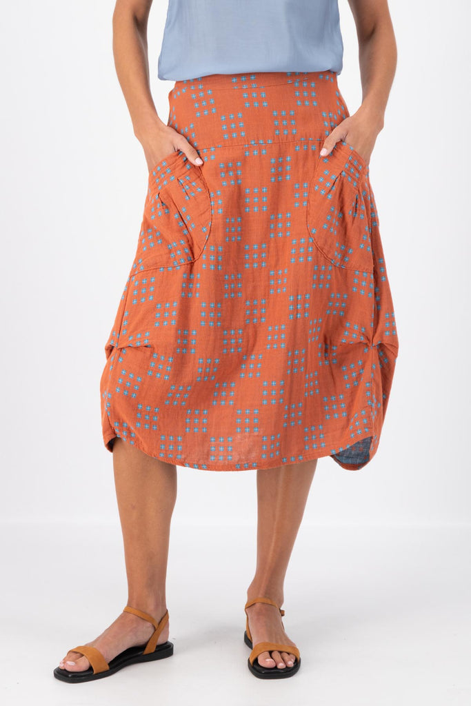 Olga de Polga Milwaukee skirt in Network Orange printed cotton. The Milwaukee is an incredibly unique, chic and original skirt. It is universally flattering, highly versatile, and super comfortable. Perfect to throw on and go. Front close-up view on model.