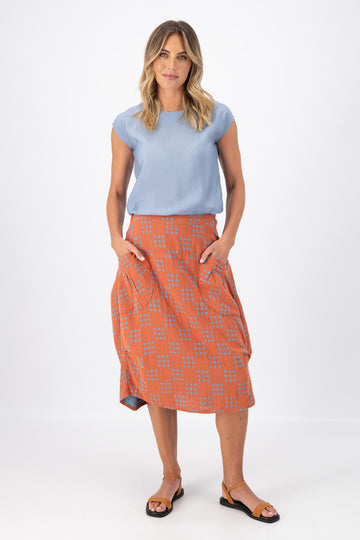 Olga de Polga Milwaukee skirt in Network Orange printed cotton. The Milwaukee is an incredibly unique, chic and original skirt. It is universally flattering, highly versatile, and super comfortable. Perfect to throw on and go. Front view on model.