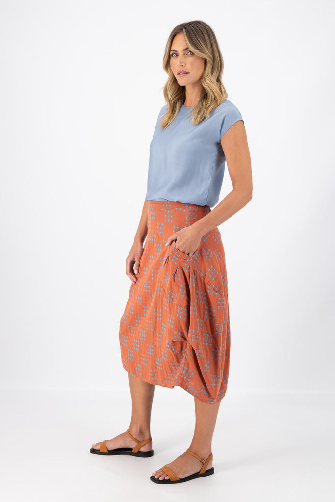 Olga de Polga Milwaukee skirt in Network Orange printed cotton. The Milwaukee is an incredibly unique, chic and original skirt. It is universally flattering, highly versatile, and super comfortable. Perfect to throw on and go. side view on model.