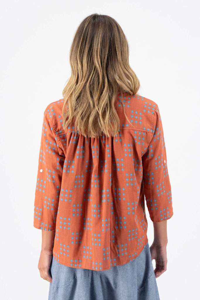 Olga de Polga Network printed cotton shirt in orange with a button down front and collar. 3/4 length sleeves with a foldable sleeve and button fastening. Back view on model.