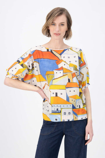 Olga de Polga Pueblito Orange Camisa blouse. Reversible with  the options of a boatneck or soft v-neck. Front view on model. 