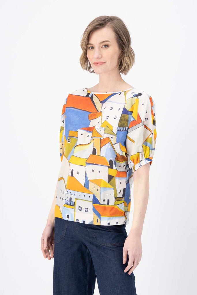 Olga de Polga Pueblito Orange Camisa blouse. Reversible with  the options of a boatneck or soft v-neck. Side view on model. 