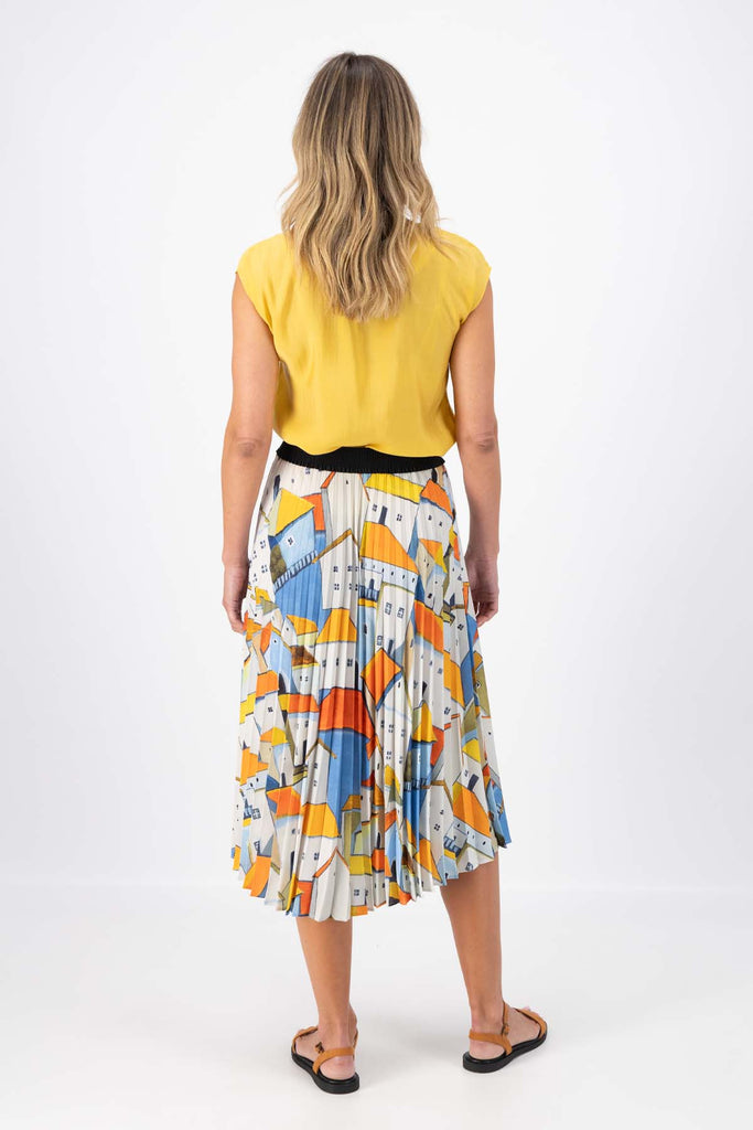 Olga de Polga Pleated skirt in the Pueblito Orange printed recycled polyester. Back view on model.