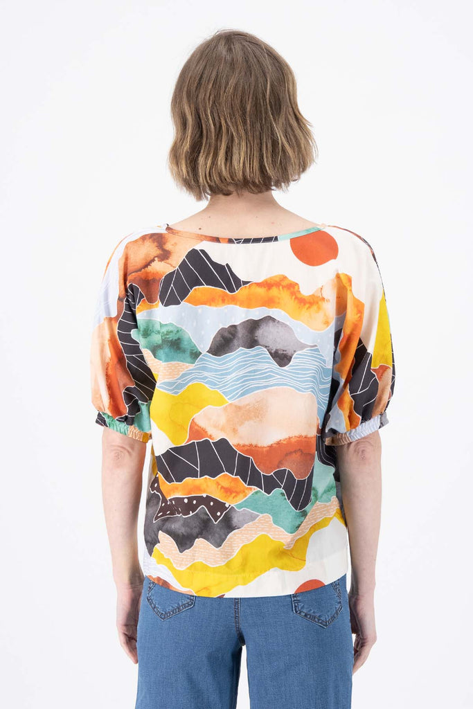 Olga de Polga Orange Vista printed cotton Camisa. Blouse. Reversible top with a soft v-neck on one side and a boat-neck on the other.
Half sleeves, with a bat-wing shape, and tapers in at the hips. Back view on model.