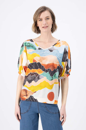 Olga de Polga Orange Vista printed cotton Camisa. Blouse. Reversible top with a soft v-neck on one side and a boat-neck on the other.
Half sleeves, with a bat-wing shape, and tapers in at the hips. Front close up view on model.