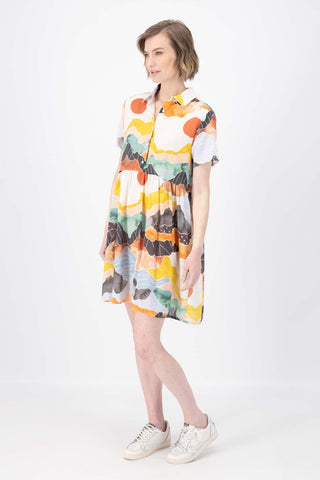 Olga de Polga Villa dress with a dropped waist in Vista Orange printed cotton seersucker. Side front view on model.