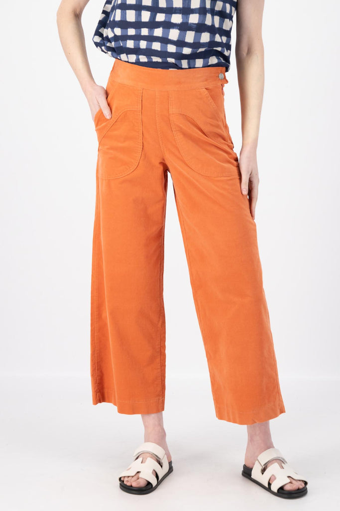 Olga de Polga Peggy Pants in Peach Fine Cotton Cord. Best seller with large front patch pockets, elasticated waistband, cropped length, side zip fastening. Front close-up view on model.