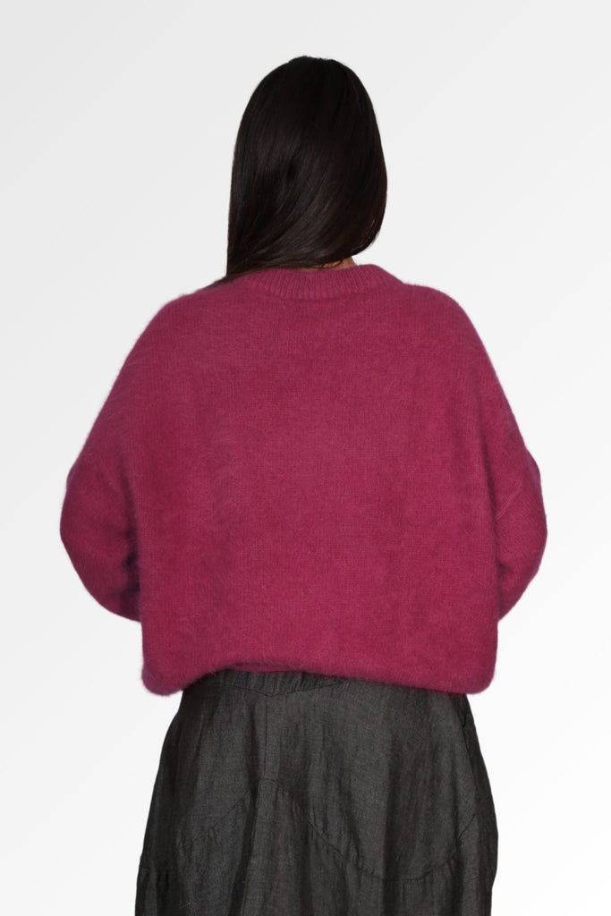 Olga de Polga cosy Women's Montreal Sweater in Angora in a soft purple plum colour. Long sleeves, cropped length, round neckline, dropped shoulders. Ribbing at neckline, cuffs and hem. Back view on model
