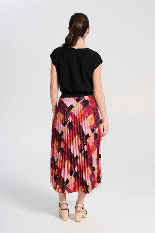 Olga de Polga classic pleated skirt in printed Kismet Blush Pink. Midi length. Fully elasticated waistband. Back view on model