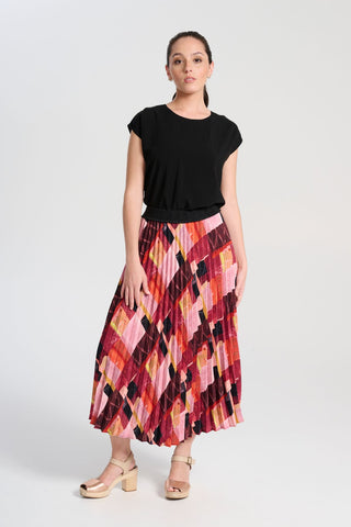 Olga de Polga classic pleated skirt in printed Kismet Blush Pink. Midi length. Fully elasticated waistband. Front view on model