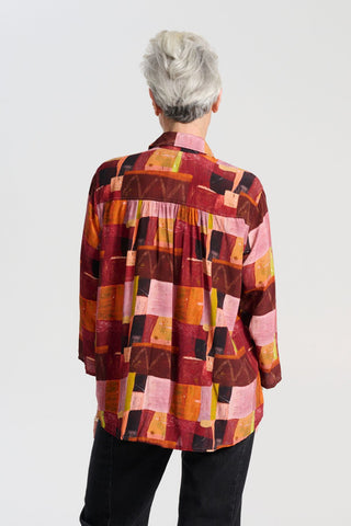 Olga de Polga classic shirt in printed viscose. Kismet Blush Print. Button down front, 3/4 sleeves and a front patch pocket. Print has colours of red, pink, burgundy and accents of yellow and orange. Back close up view