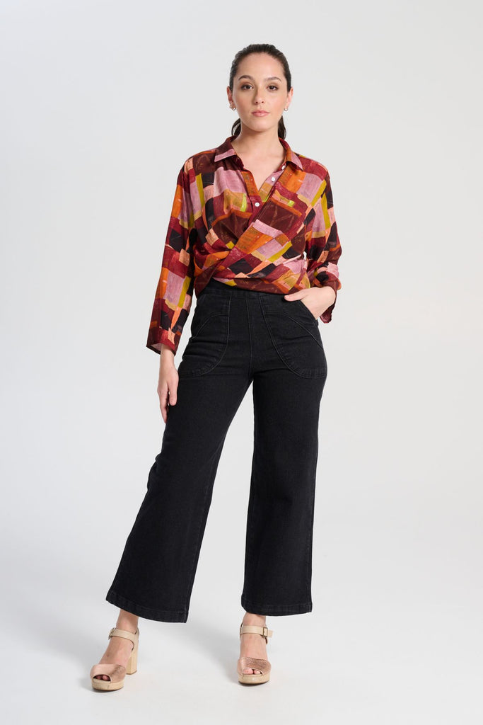 Olga de Polga classic shirt in printed viscose. Kismet Blush Print. Button down front, 3/4 sleeves and a front patch pocket. Print has colours of red, pink, burgundy and accents of yellow and orange. Front full length view with jeans.