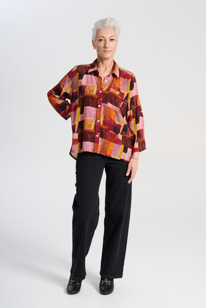 Olga de Polga classic shirt in printed viscose. Kismet Blush Print. Button down front, 3/4 sleeves and a front patch pocket. Print has colours of red, pink, burgundy and accents of yellow and orange. Front full length view 