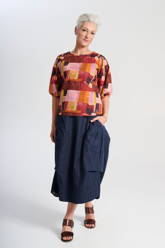 Olga de Polga classic printed blouse in Kismet Blush print. Pinks, reds and burgundy with accents of yellow and orange. Round neckline and lantern shaped sleeves. Front full length view.