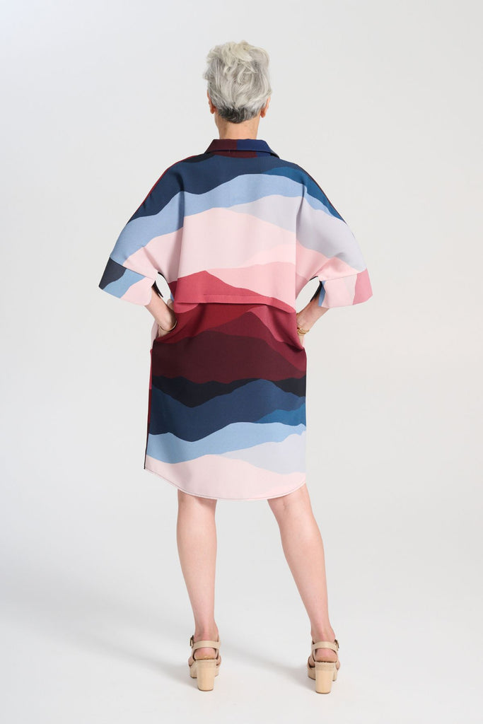 Olga de Polga Kona Skylone Estilo Shift dress in heavy crepe. With a shirt collar and buttons at the neck. Half sleeves with a batwing shape. Knee length. Back view on model